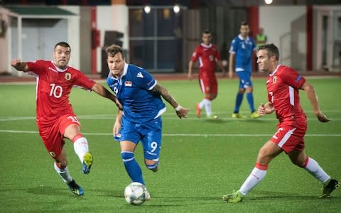 Gibraltar's Liam Walker, left and Liechtenstein's Marcel Buchel challenge for the ball during the UEFA Nations League soccer match between Gibraltar and Liechtenstein at the Victoria Stadium in Gibraltar - Credit: AP