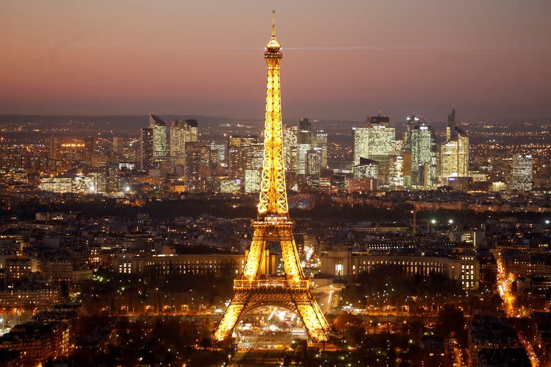 FILE PHOTO: A general view show the illuminated Eiffel Tower and the skyline of La Defense business district at night in Paris