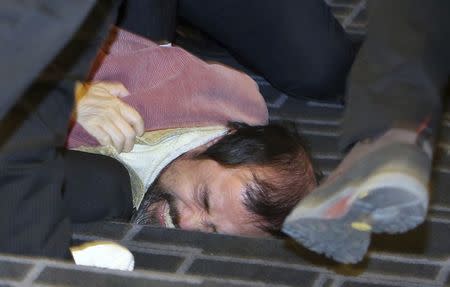 Security personnel detain an unidentified assailant who attacked the U.S. ambassador to South Korea Mark Lippert at a public forum, in central Seoul March 5, 2015. REUTERS/Yonhap