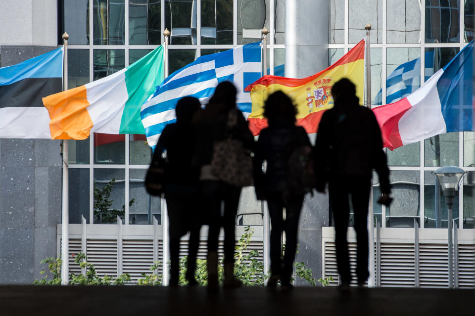 People walk in front of flags of European countries outside the European Parliament in Brussels, Friday, Oct. 12, 2012. The European Union won the Nobel Peace Prize on Friday for its efforts to promote peace and democracy in Europe, despite being in the midst of its biggest crisis since the bloc was created in the 1950s. (AP Photo/Geert Vanden Wijngaert)