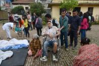 Nepalese people wheel an injured man into an open area after a powerful 7.9 earthquake shook Lalitpur on the outskirts of Kathmandu, on April 25, 2015