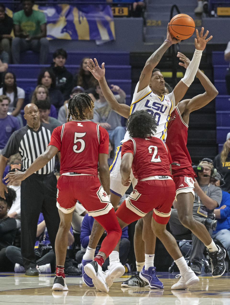 LSU forward Derek Fountain (20) gets works between Nicholls forward Diante Smith (5), guard Robert Brown III (2), and forward Mekhi Collins (0) during an NCAA college basketball game Friday, Nov. 10, 2023, in Baton Rouge, La. (Hilary Scheinuk/The Advocate via AP)