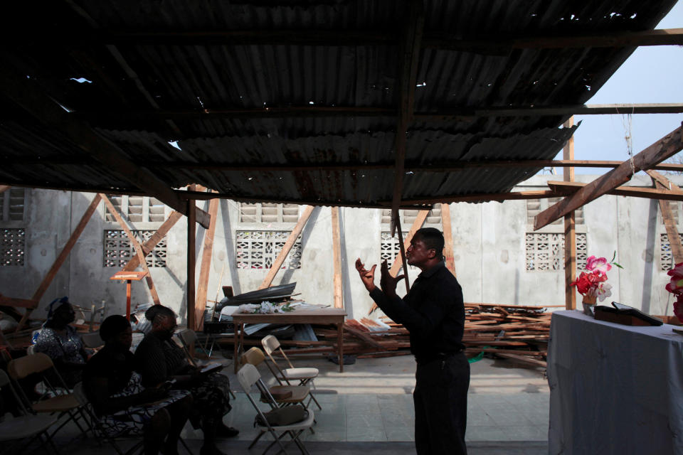 A pastor leads a prayer&nbsp;in a damaged church&nbsp;on&nbsp;Oct. 16, 2016.