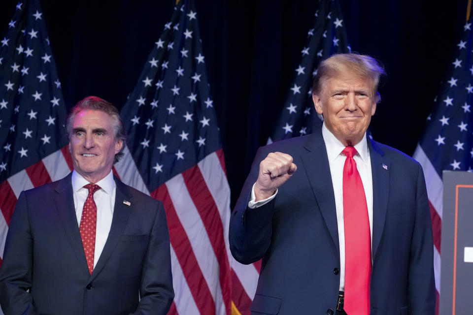 FILE - Republican presidential candidate former President Donald Trump arrives to speak at a caucus night rally in Las Vegas, Feb. 8, 2024, as North Dakota Gov. Doug Burgum watches. (AP Photo/Alex Brandon, File)