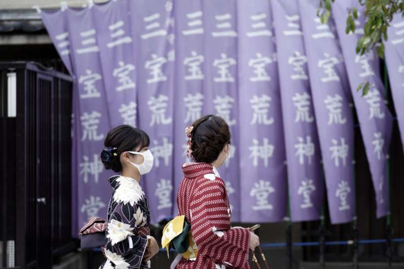 日本疫情升高，東京淺草區的往來行人都戴著口罩。（美聯社）