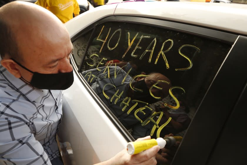 LOS ANGELES , CA - SEPTEMBER 22: Carlos Barrera who has worked in valet parking for 40 years at the Chateau Marmont writes messages the window of his car in support of workers who lost their jobs at the Chateau Marmont as they form a caravan of hotel workers to travel from the LA area to Sacramento to protest in favor of a bill that would protect their jobs. Hotel workers from around Southern California join workers at the Chateau Marmont on Sunset Blvd Tuesday morning where they picketed to drivers passing's on Sunset Blvd. Several hotels are cutting operations because of the financial effects of the COVID-19 crisis. Chateau Marmont on Tuesday, Sept. 22, 2020 in Los Angeles , CA. (Al Seib / Los Angeles Times