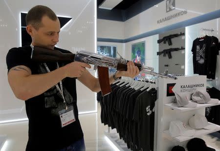 A salesperson demonstrates a model AK-47 assault rifle at the newly opened Gunmaker Kalashnikov souvenir store in Moscow's Sheremetyevo airport, Russia, August 22, 2016. REUTERS/Maxim Shemetov