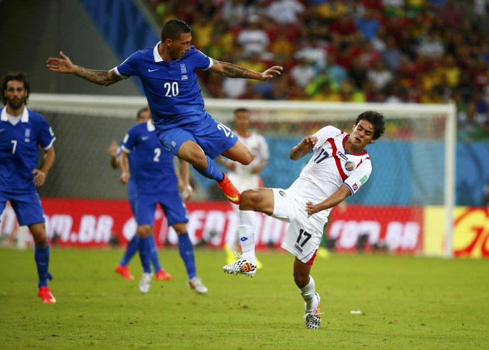 Greece's Jose Holebas (L) challenges Costa Rica's Yeltsin Tejeda during their 2014 World Cup round of 16 game at the Pernambuco arena in Recife June 29, 2014. REUTERS/Tony Gentile