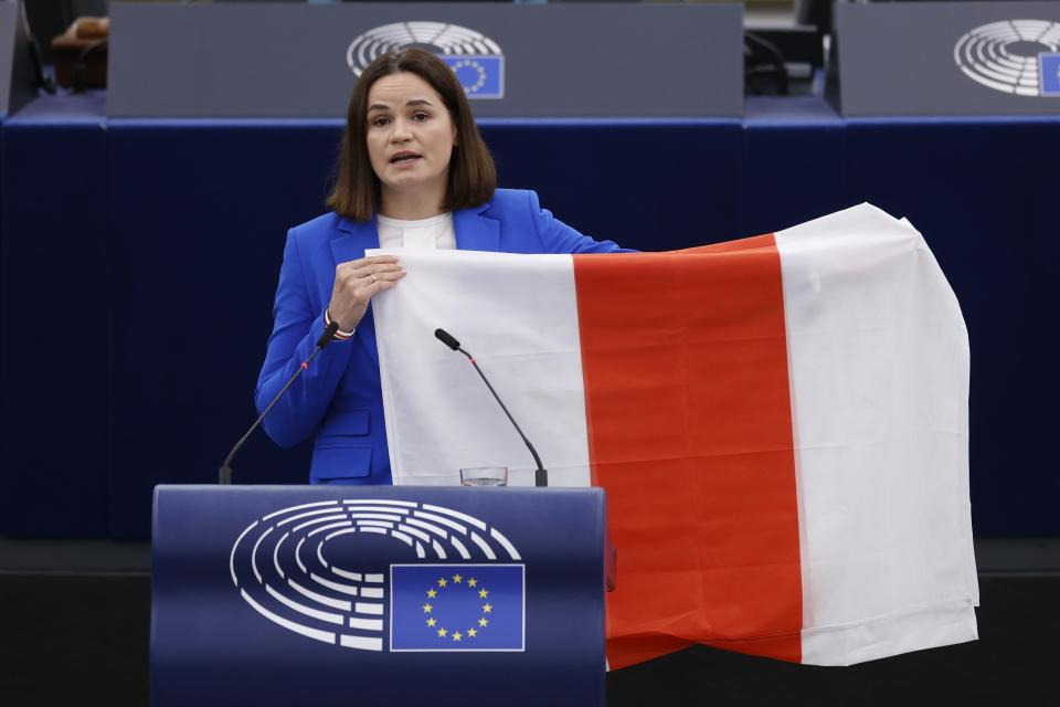 FILE - Exiled Belarusian opposition leader Sviatlana Tsikhanouskaya displays a flag symbolizing the Belarus opposition as she delivers her speech at the European Parliament, on Sept. 13, 2023 in Strasbourg, eastern France. Authorities in Belarus have announced raids and the seizure of property of 104 opposition activists who have fled the country. The action announced on Thursday, May 16, 2024 was the latest step in the crackdown on dissent that has continued unabated for nearly four years. (AP Photo/Jean-Francois Badias, File)