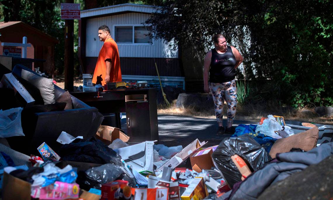 Enee Pradia Sr and his partner Keshayla Brux look over their personal belongings that had been dumped on the street corner after they were evicted from their home at the Little Lake Mobile Home Park in Roy, Washington on Thursday, Sept. 8, 2022.