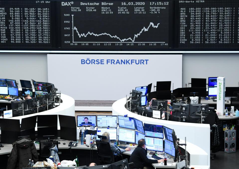16 March 2020, Hessen, Frankfurt/Main: Stock traders work in the trading room of the Frankfurt Stock Exchange in front of the display board with the Dax curve. As a result of the worsening coronavirus crisis, the German share index Dax has fallen below the 9000 point mark. Photo: Arne Dedert/dpa (Photo by Arne Dedert/picture alliance via Getty Images)