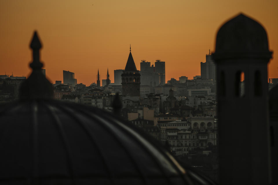 The city's landmark Galata Tower is seen as worshippers offer the Eid al-Fitr prayer amid concerns of the coronavirus outbreak at historical Suleymaniye Mosque, in Istanbul, early Sunday, May 24, 2020. Muslims in the world are marking a muted and gloomy religious festival of Eid al-Fitr, the end of the fasting month of Ramadan _ a usually joyous three-day celebration that has been significantly toned down due to the new coronavirus outbreak.(AP Photo/Emrah Gurel)