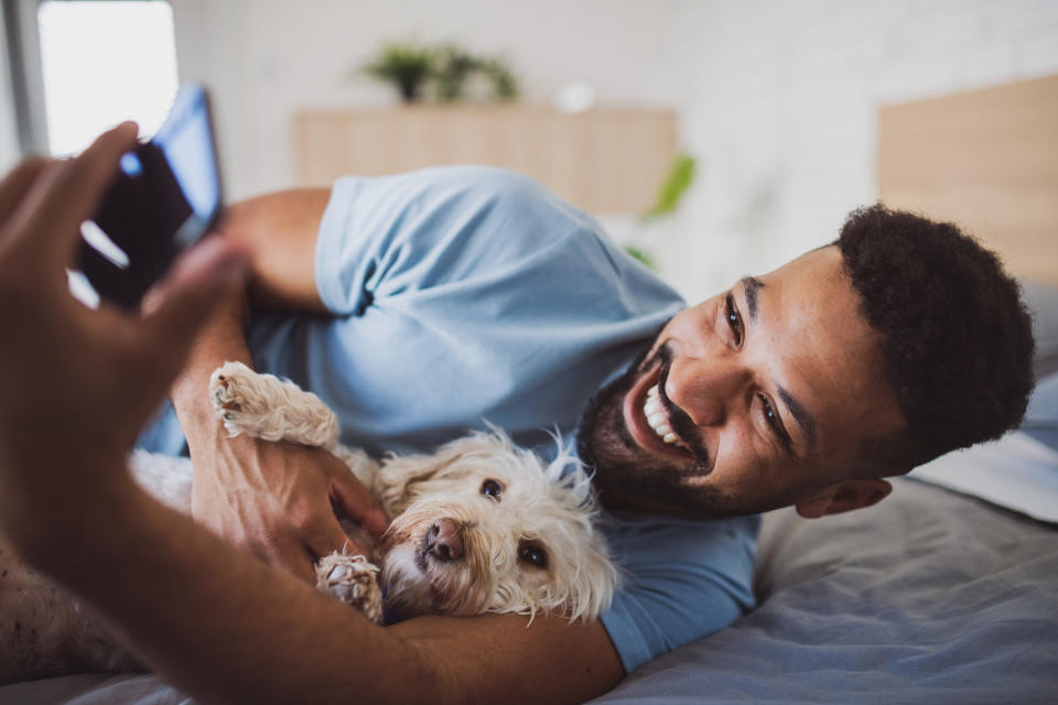 A man taking a photo of him and his dog