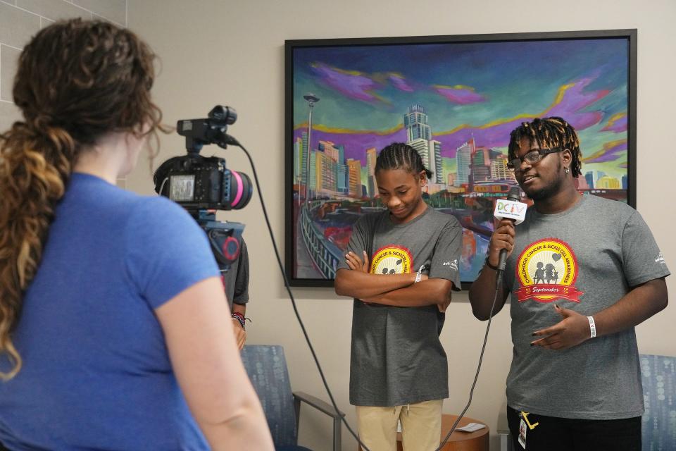 Sickle Cell Squad members Donalvon Ross, left, and Chris Gibson, right, participate in a video with production coordinator Alyssa Rueter to be shown on the hospital's channel for patients.