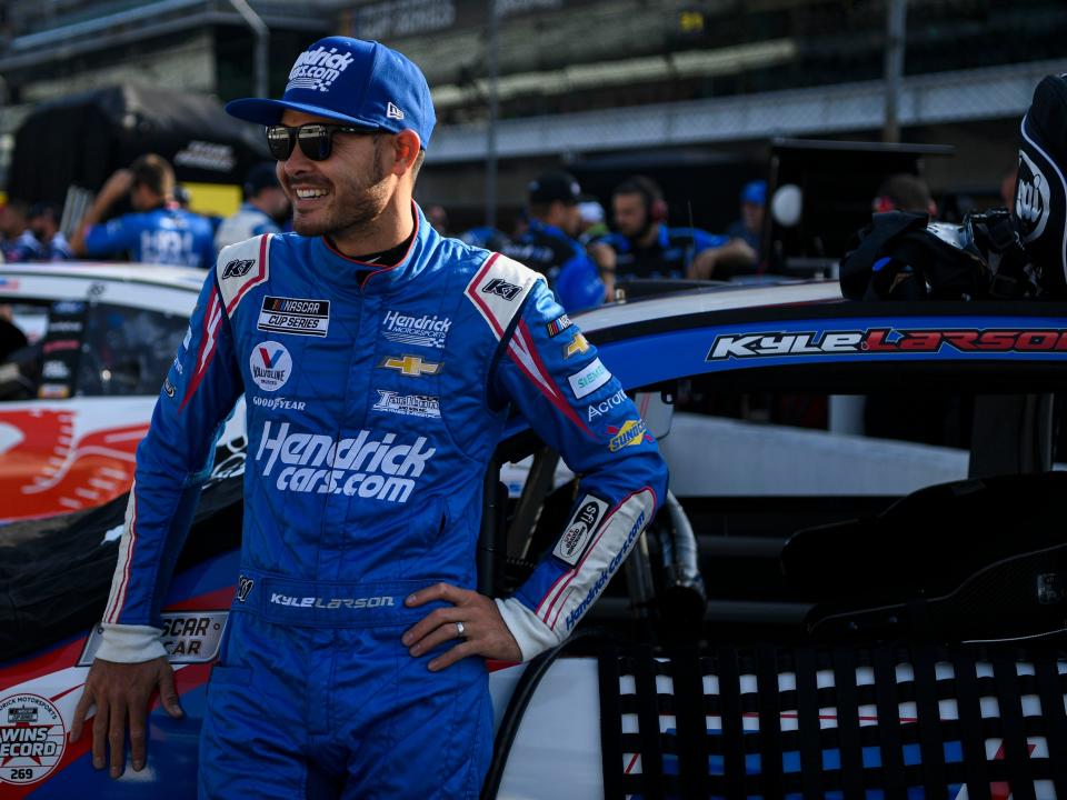 NASCAR driver Kyle Larson (5) leans against his car as he does an interview with a television crew in the pit, Sunday, Aug. 15, 2021, during qualifying for the Verizon 200 at the Brickyard at Indianapolis Motor Speedway. 