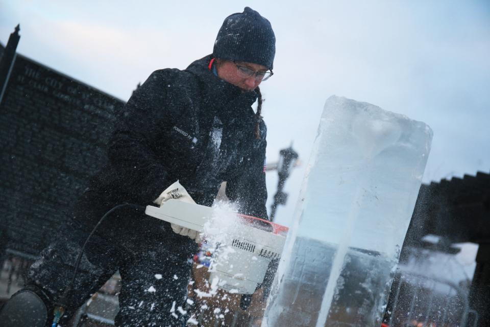 Kaitlin Pfropper, a professional ice carver, is commissioned to carve multiple ice sculptures for local businesses during the opening night of St. Clair's Icy Bazaar event at the Riverview Plaza in St. Clair on Thursday, Jan. 20, 2022.