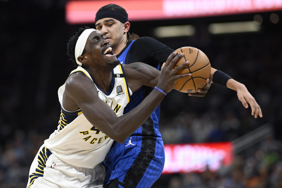 Indiana Pacers forward Pascal Siakam, front left, is fouled by Orlando Magic guard Anthony Black, back right, while driving to the basket during the first half of an NBA basketball game, Sunday, March 10, 2024, in Orlando, Fla. (AP Photo/Phelan M. Ebenhack)