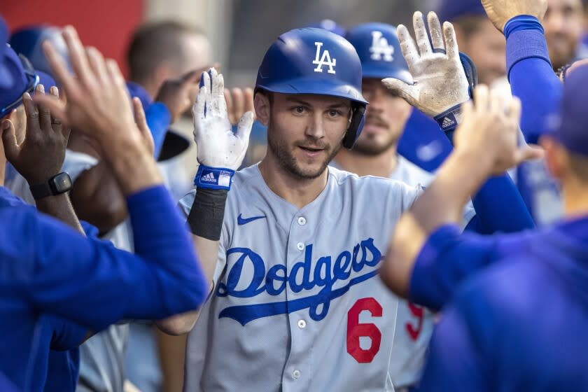 Los Angeles Dodgers' Trea Turner, center, is congratulated in the dugout.