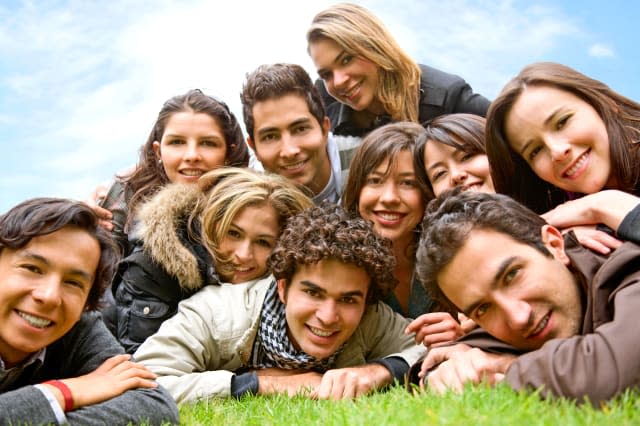 happy group of friends smiling outdoors in a park