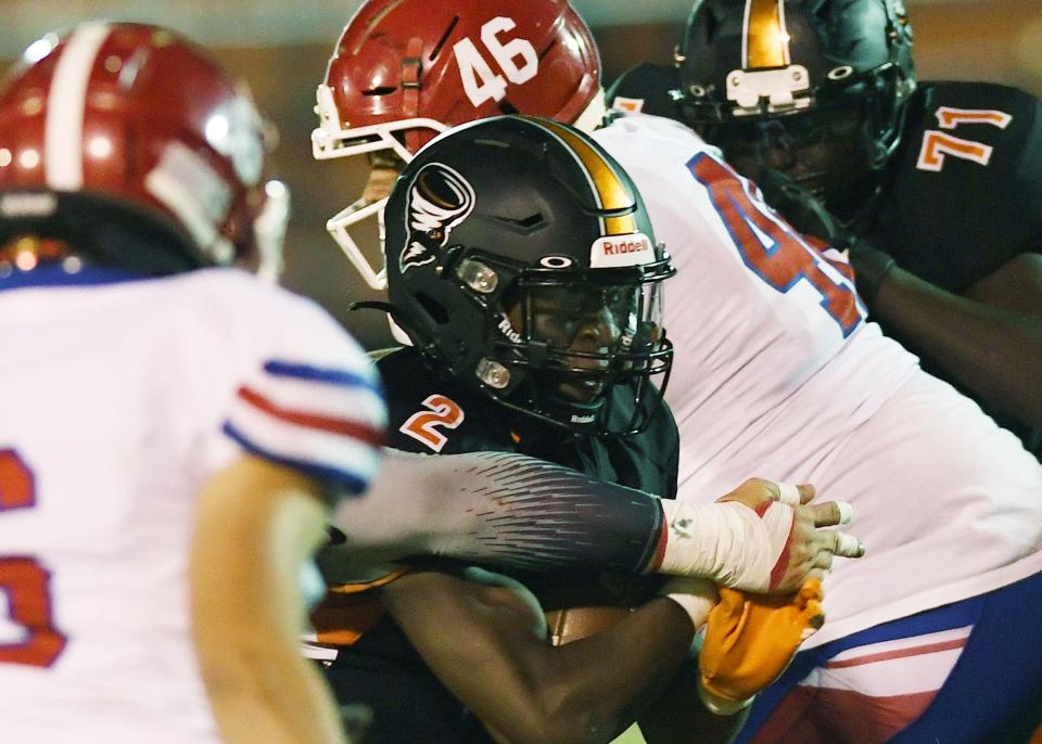 Ames running back Jamison Poe (2) battles for a few yards after getting tackled by Council Bluffs Lincoln linebacker Miguel Olivares (46) during the first quarter of the Little Cyclones' 42-13 victory Sept. 30 in Ames.