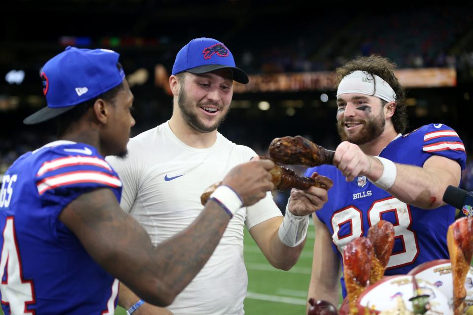 Nov 25, 2021; New Orleans, Louisiana, USA; Buffalo Bills wide receiver Stefon Diggs (14) and quarterback Josh Allen (17) and tight end Dawson Knox (88) enjoy a turkey leg at the end of their game against the New Orleans Saints at the Caesars Superdome. Mandatory Credit: Chuck Cook-USA TODAY Sports