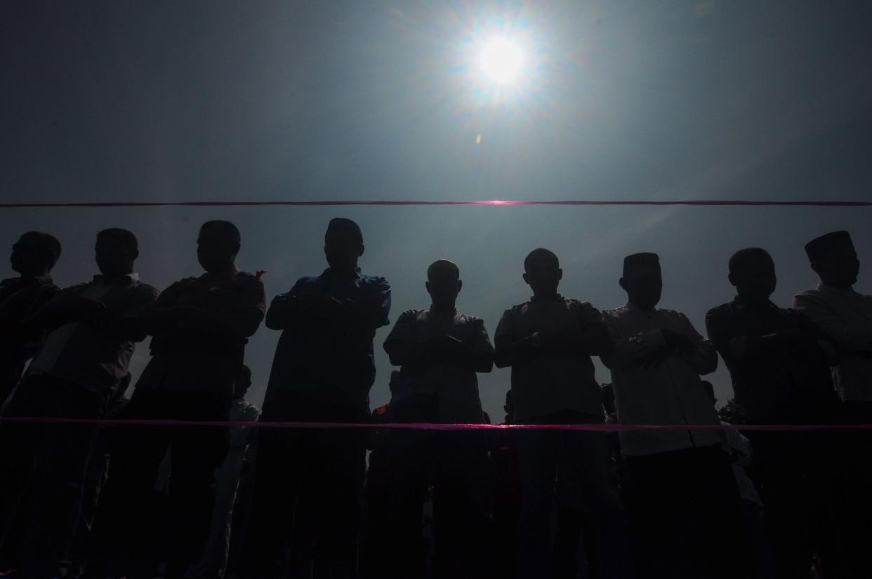People pray during a rare "ring of fire" solar eclipse in Indonesia's Riau province in December 2019.