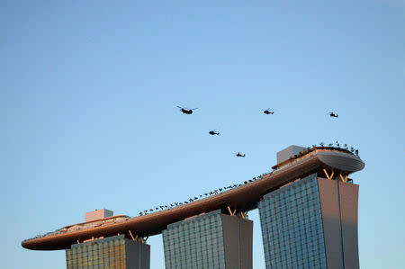 Republic of Singapore Air Force (RSAF) helicopters fly in formation above the Marina Bay Sands integrated resort during a rehearsal for the country's National Day Parade in Singapore June 26, 2010. REUTERS/Kevin Lam/File Photo