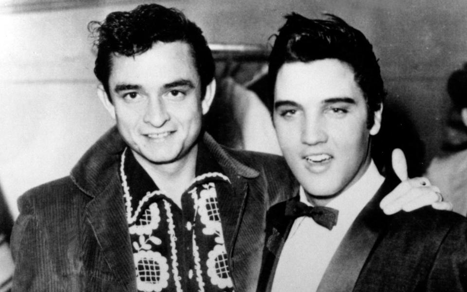 1955 trat Johnny Cash (links) gemeinsam mit dem aufstrebenden Rock'n'Roll-Star Elvis Presley (Bild) auf, auch Carl Perkins war Teil der gemeinsamen Shows. Letzterem, so behauptete Cash, erzählte er vom einem Armee-Kollegen, der nicht wollte, dass man ihm auf seine "Blue Suede Shoes" tritt. Perkins wiederum sagte, er habe die Phrase, die zu seinem größten Hit wurde, woanders aufgeschnappt. (Bild: Michael Ochs Archives/Getty Images)
