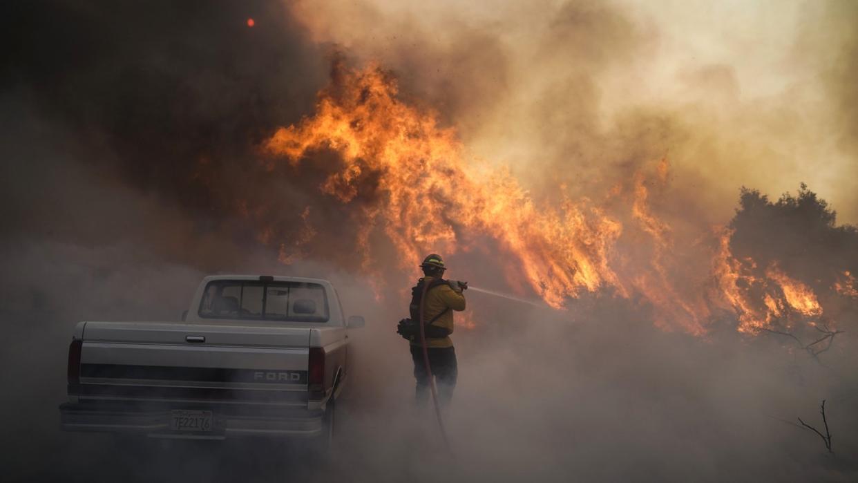 Ein Feuerwehrmann versucht, gegen die Flammen anzukämpfen.