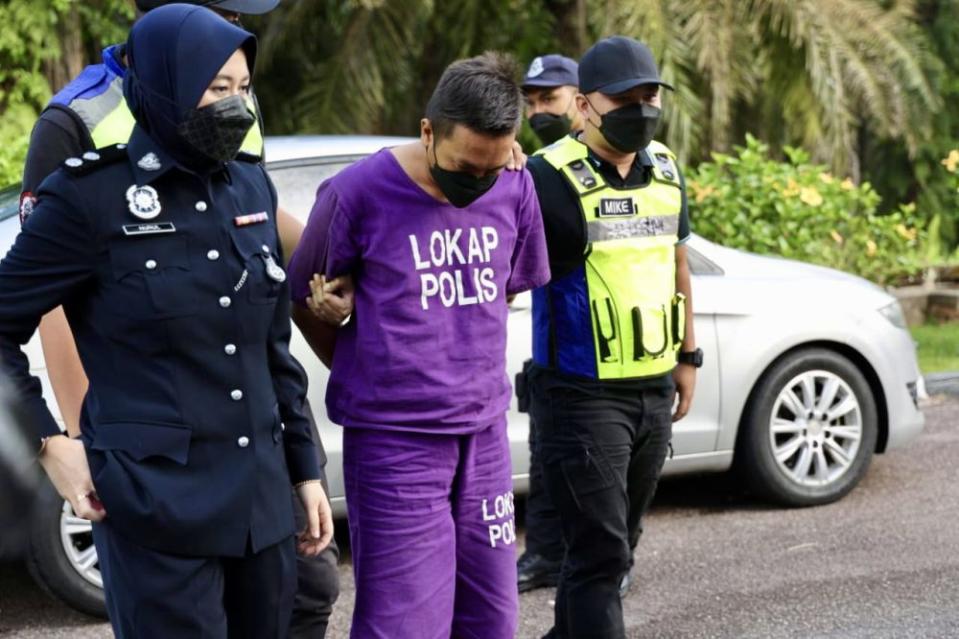 The accused Hadi Hashim is escorted by police at the Kota Tinggi Sessions Court April 26, 2022. — Picture by Ben Tan