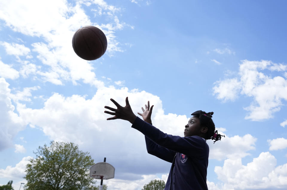 Ayomide plays catch in the playground of the Holy Family Catholic Primary School in Greenwich, London, Wednesday, May 19, 2021. (AP Photo/Alastair Grant)