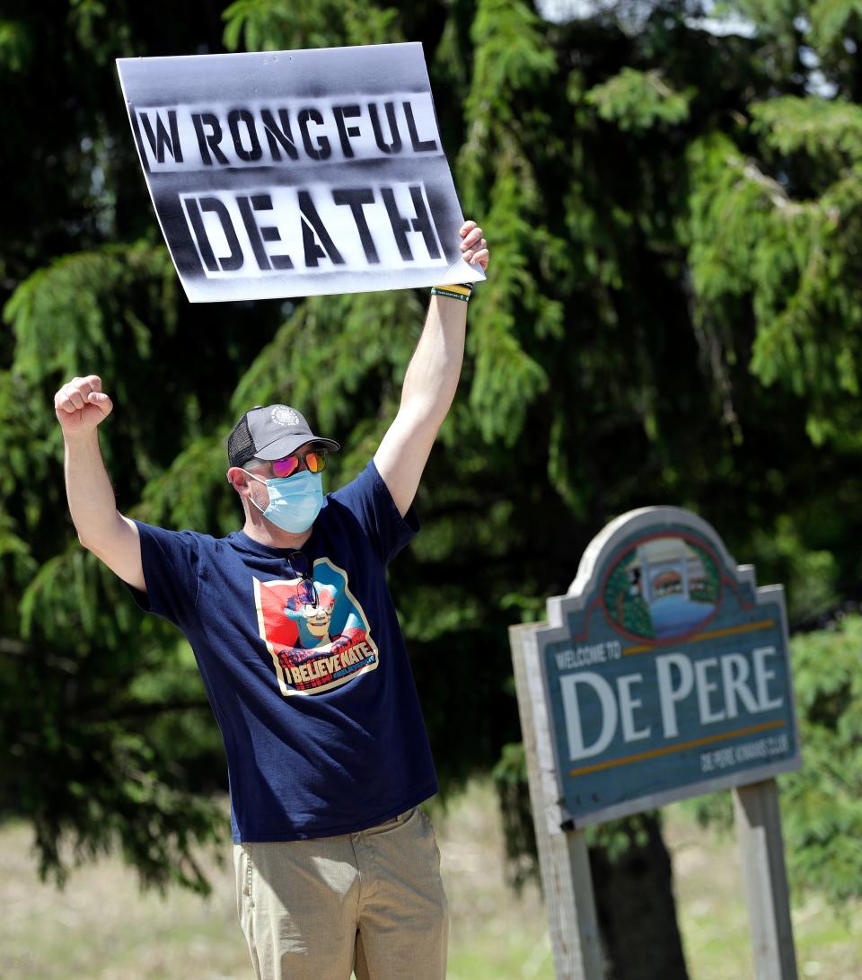 Lawrence Chetchuti, friend of Nate Lindstrom and Green Bay resident, protests along Webster Avenue outside St. Norbert Abbey on June 6, 2020, at the De Pere-Allouez border. Lindstrom, 45, said three priests sexually abused him as a teen; he died by suicide in March 2020.