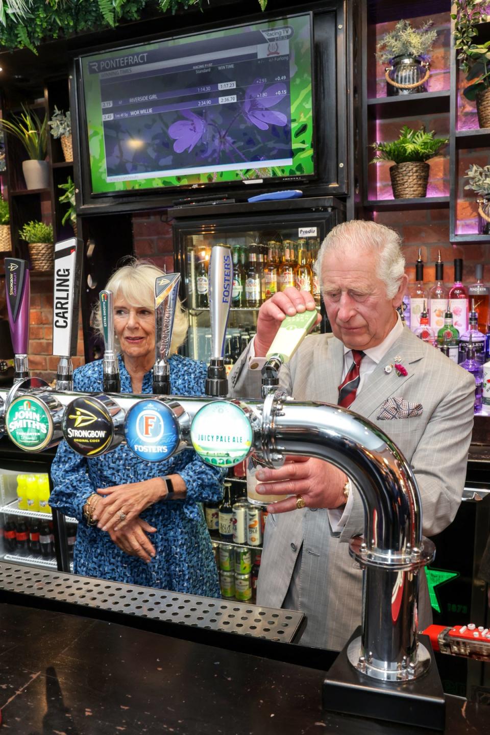 The then-Prince of Wales and the Duchess of Cornwall behind the bar at The Lion pub during a visit to Treorchy in July (Chris Jackson/PA) (PA Wire)