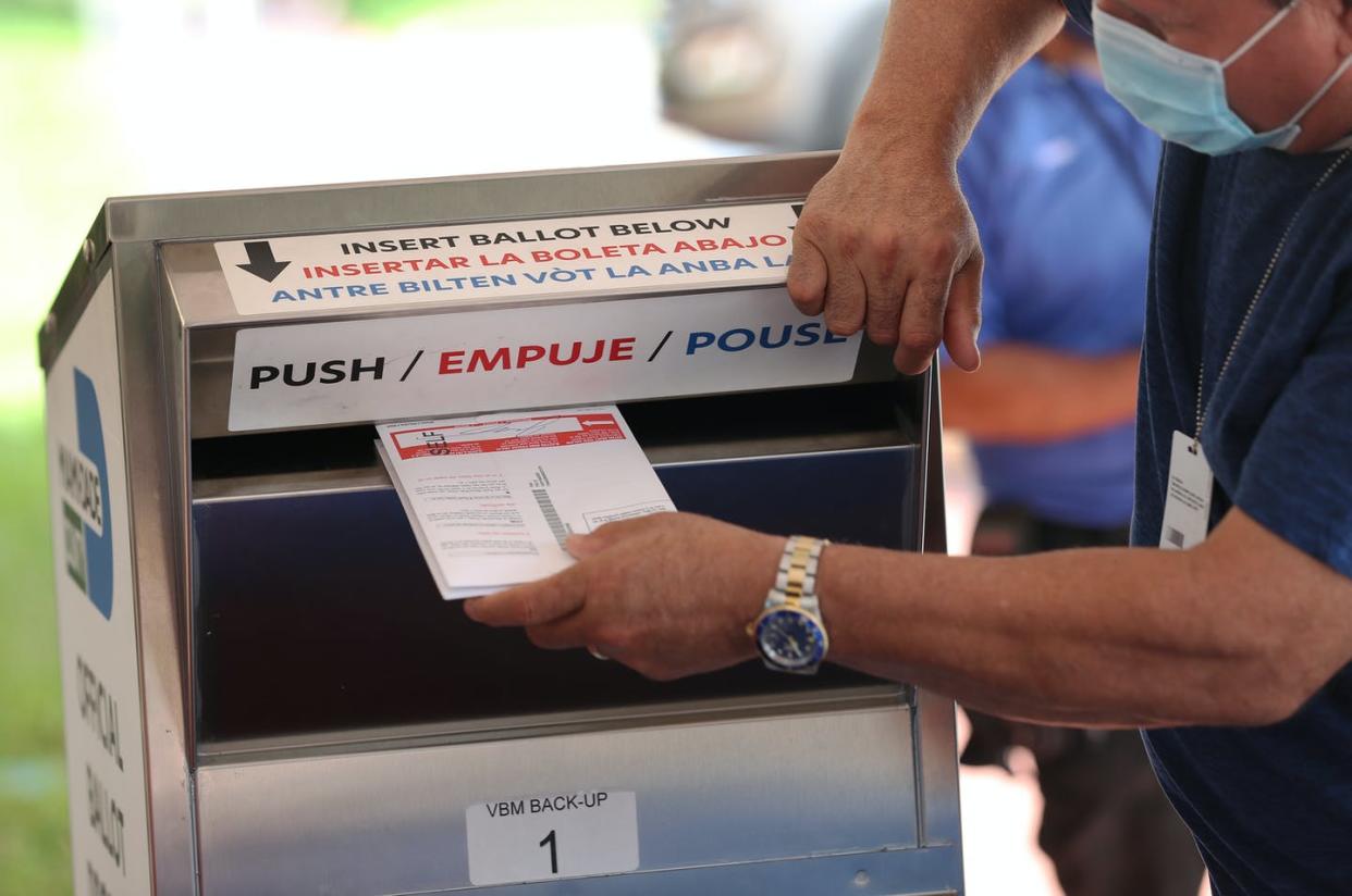 <span class="caption">A poll worker places vote-by-mail ballots into a ballot box set up at the Miami-Dade Election Department headquarters on Oct. 14, 2020 in Doral, Fla.</span> <span class="attribution"><a class="link " href="https://www.gettyimages.com/detail/news-photo/poll-workers-places-vote-by-mail-ballots-into-a-ballot-box-news-photo/1280201205" rel="nofollow noopener" target="_blank" data-ylk="slk:Joe Raedle/Getty Images News via Getty;elm:context_link;itc:0;sec:content-canvas">Joe Raedle/Getty Images News via Getty</a></span>