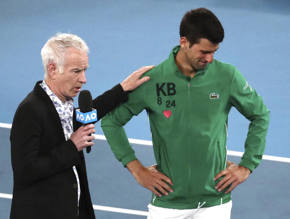 Serbia's Novak Djokovic reacts as he is interviewed by John McEnroe about the death of his friend Kobe Bryant following his quarterfinal win over Canada's Milos Raonic at the Australian Open tennis championship in Melbourne, Australia, Tuesday, Jan. 28, 2020.(AP Photo/Dita Alangkara)