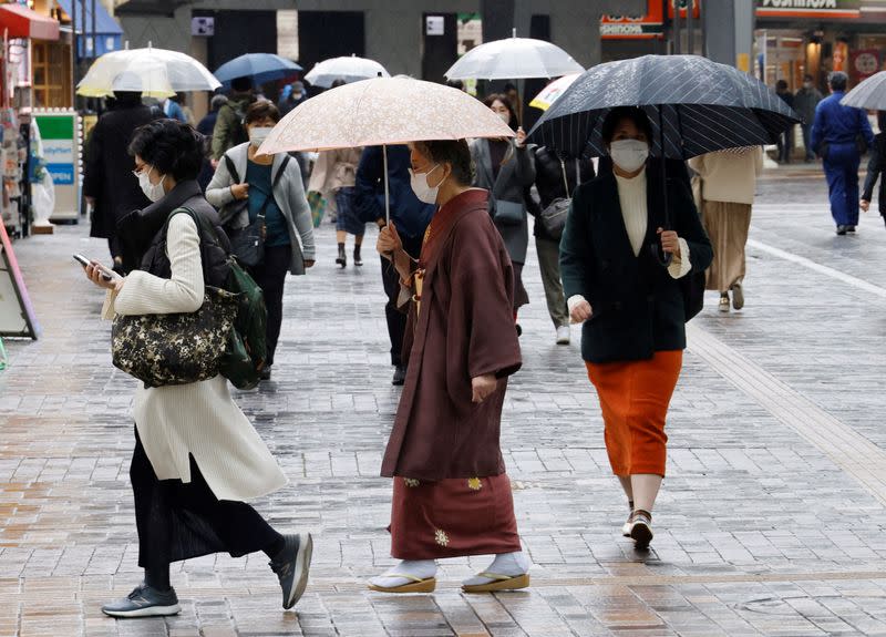 A woman in a traditional costume makes her way at a shopping district in Tokyo