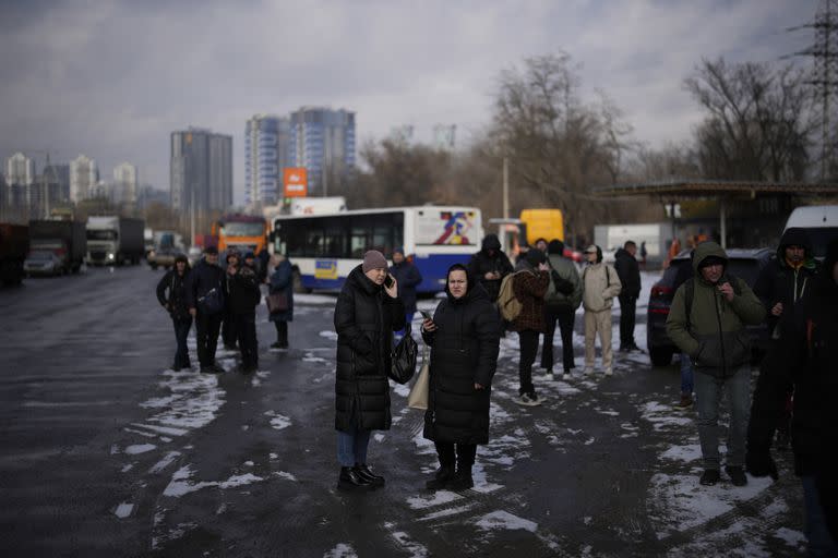 La gente espera en una calle bloqueada por la policía después de un ataque con cohetes en Kiev, Ucrania, jueves 26 de enero de 2023.