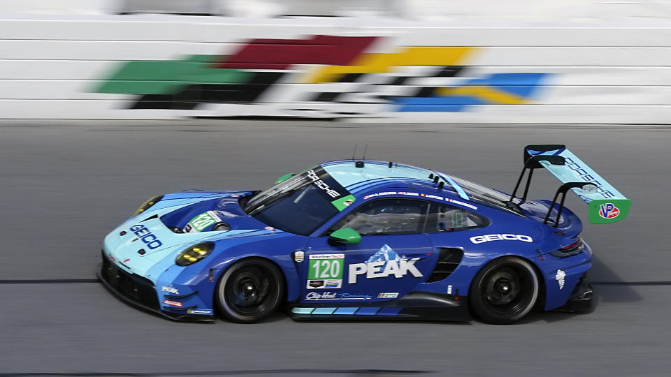 The Wright Motorsports Porsche 911 takes in laps during a practice session for the Rolex 24 hour auto race at Daytona International Speedway, Thursday, Jan. 25, 2024, in Daytona Beach, Fla. The car will also double for a car that will appear in an upcoming movie starring actor Brad Pitt. (AP Photo/John Raoux)