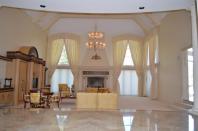 Aus dem Foyer geht es in das ebenfalls marmorgeflieste Wohnzimmer, das von seinen Ausmaßen her eher einem Ballsaal gleicht. Natürlich verfügt es über einen riesigen Kamin sowie Kronleuchter. Insgesamt kommt das Anwesen auf sechs Schlaf- und elf Badezimmer.