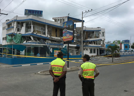 Police officers stand near a damaged building after a 5.8-magnitude earthquake shook Ecuador's Pacific coast early on Monday, in Atacames, Ecuador, December 19, 2016. REUTERS/Ricardo Landeta