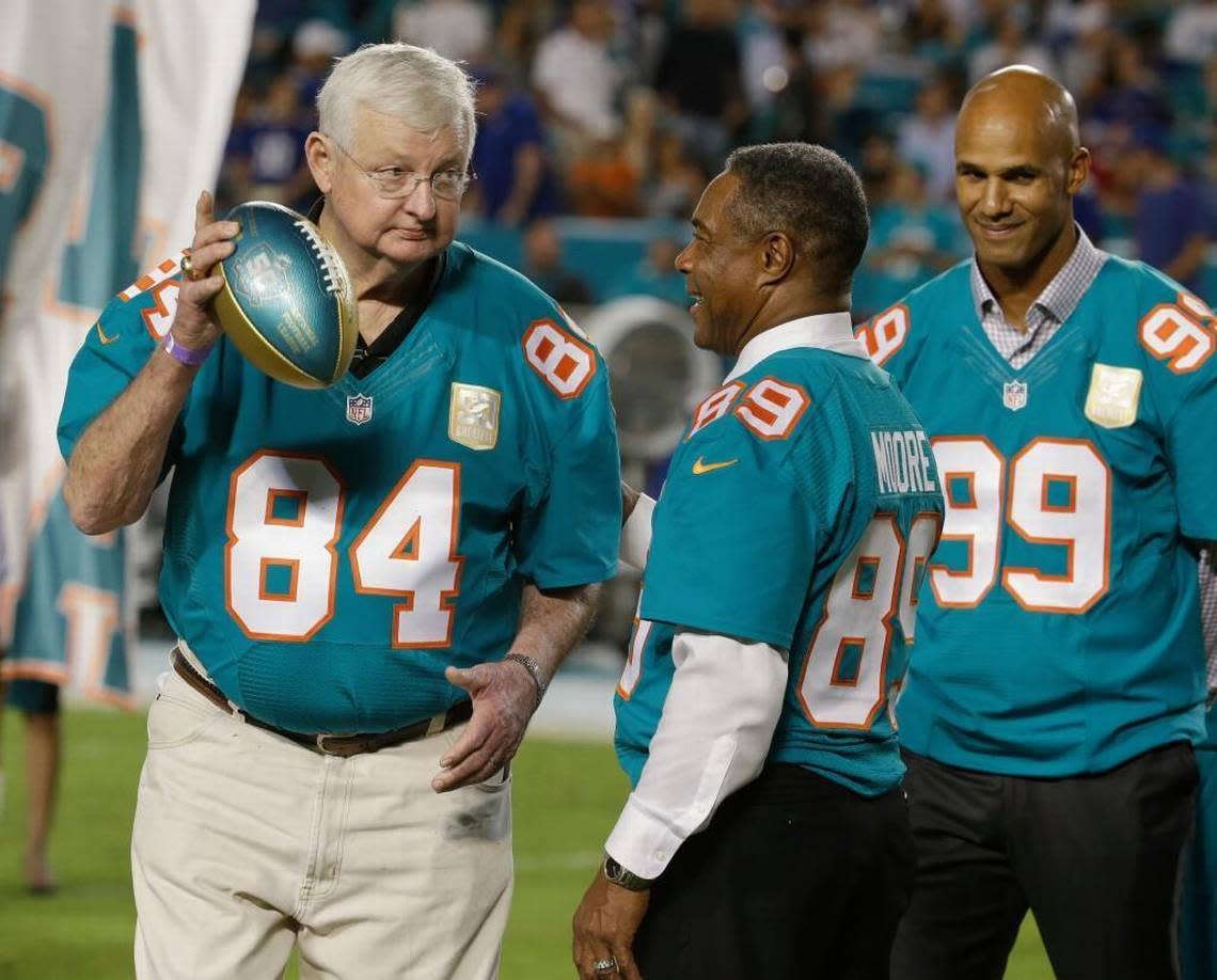 In this Dec. 14, 2015, file photo, former Miami Dolphins player Bill Stanfill (84) is presented a football by former player and current Dolphins senior vice president of special projects and alumni relations, Nat Moore (89) during the Dolphins All-Time 50th Anniversary Team ceremony during half time at an NFL football game against the New York Giants, in Miami Gardens, Fla. Former Georgia and Miami Dolphins star Bill Stanfill has died. He was 69. The university issued a statement on behalf of Stanfill’s family saying he died Thursday night, Nov. 10, 2016, in Albany, Ga.