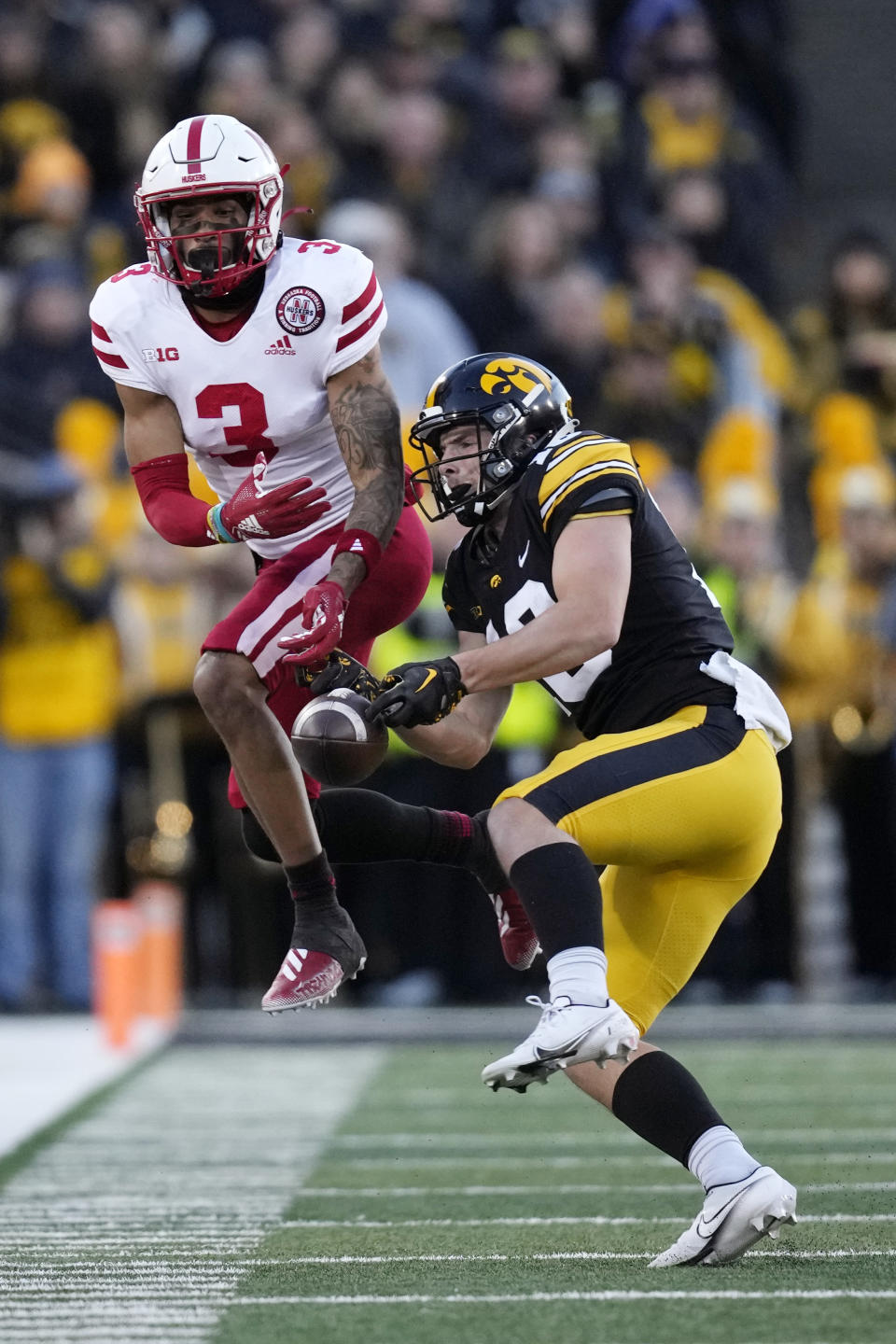 Iowa defensive back Jamison Heinz breaks up a pass intended for Nebraska wide receiver Trey Palmer (3) during the first half of an NCAA college football game, Friday, Nov. 25, 2022, in Iowa City, Iowa. (AP Photo/Charlie Neibergall)