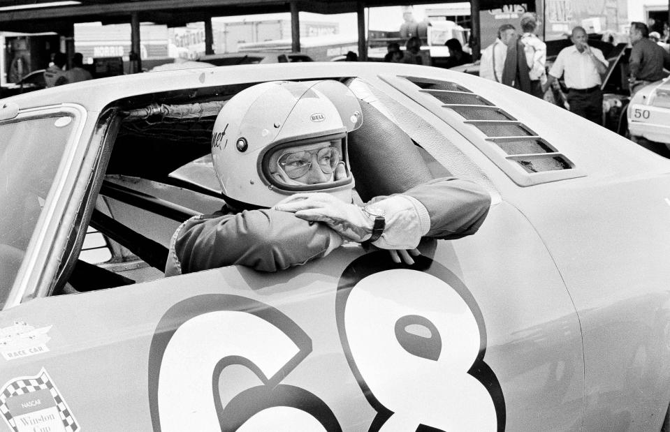 FILE - Between practice runs for the World 600, Janet Guthrie leans out of the window of the stock car racer in Charlotte, N.C., May 29, 1976. Guthrie will be inducted into the NASCAR Hall of Fame on Friday night, Jan. 19, 2024, as recipient of the Landmark Award that honors “significant contributions to the growth and esteem of NASCAR.” (AP Photo/Harold Valentine, File)