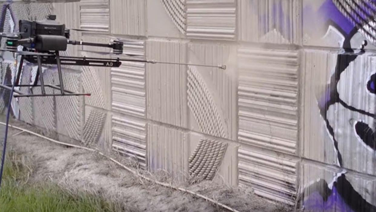 <div>A prototype drone test sprays paint to cover up graffiti in Tacoma earlier this spring (Credit: WSDOT)</div>