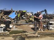 Two people stand in front of a destroyed business in Wynne, Ark., on Saturday, April 1, 2023. Unrelenting tornadoes that tore through parts of the South and Midwest that shredded homes and shopping centers. (AP Photo/Adrian Sainz)