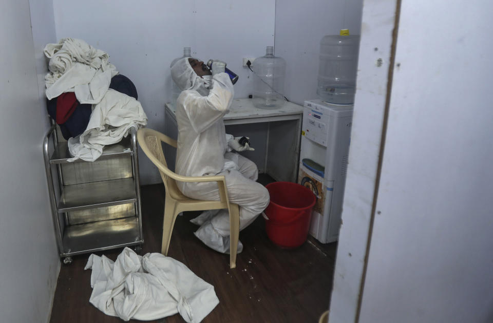 A health worker takes a water break at the BKC jumbo field hospital, one of the largest COVID-19 facilities in Mumbai, India, Friday, May 7, 2021.(AP Photo/Rafiq Maqbool)