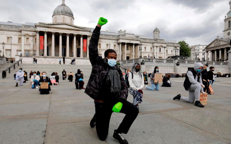 A protester makes a Black Lives Matter fist at a demonstration in Trafalgar Square in central London on Friday - Tolga Akmen/AFP