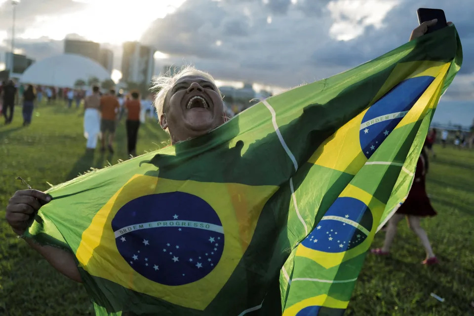 Uma pessoa apoiadora do presidente Lula presente em sua posse segura uma bandeira do Brasil, em 1&#xba; de janeiro de 2022, em Bras&#xed;lia (Foto: Reuters / Lucas Landau)