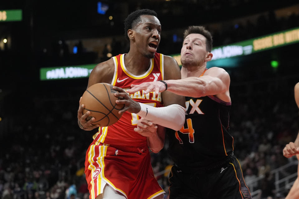 Atlanta Hawks forward Onyeka Okongwu (17) is defended by Phoenix Suns forward Drew Eubanks (14) as he drives in the first half of an NBA basketball game Friday, Feb. 2, 2024, in Atlanta. (AP Photo/John Bazemore)