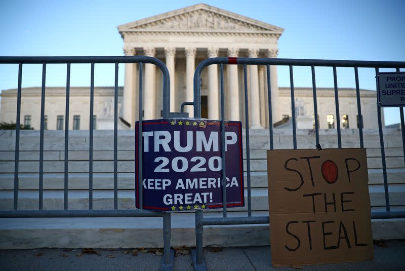 FILE PHOTO: Signs by supporters of U.S. President Donald Trump hang outside the U.S. Supreme Court building in Washington